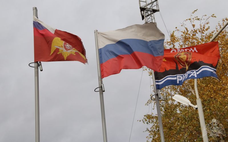 Флаги России, Росгвардии и рижского ОМОНа на праздновании годовщины образования тюменского ОМОНа.