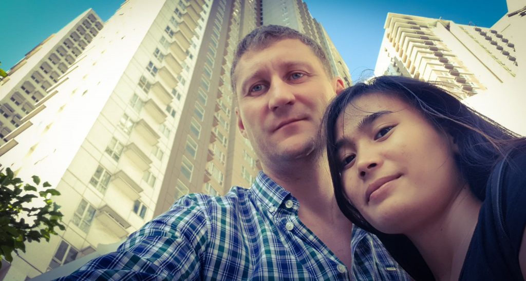 Сергей со своей девушкой на фоне многоквартирного дома, селфи