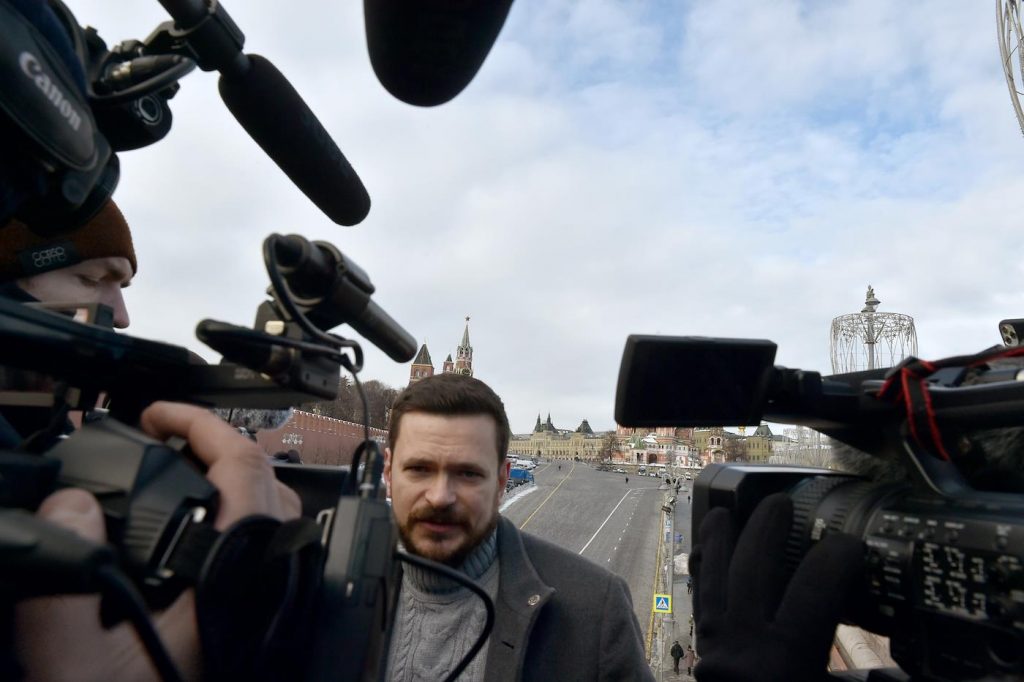 Илья Яшин в окружении репортеров на фоне Красной площади