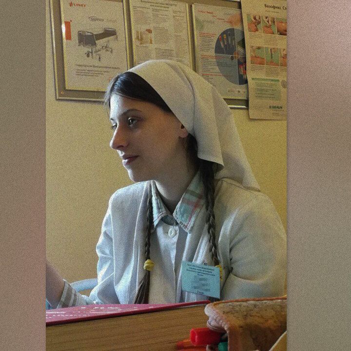 Аграфена в платке и халате на занятии в православном училище, где она училась на сестру милосердия