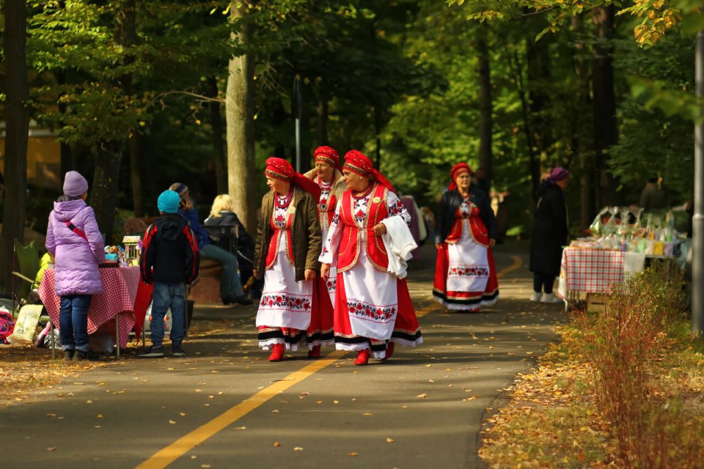 Бабушки в национальной одежде идут по парку в городе Буча