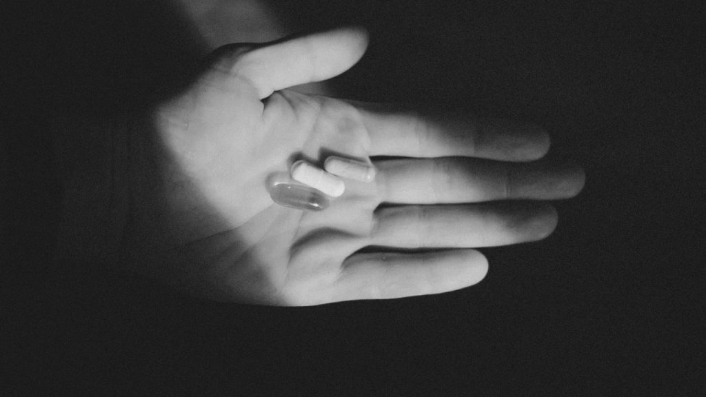 Маскированная депрессия, черно-белая фотография, иллюстрирующая прием антидепрессантов