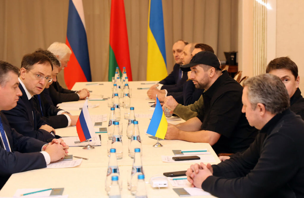Российская (слева) и украинская (справа) делегации на мирных переговорах. Денис Киреев — справа на заднем плане