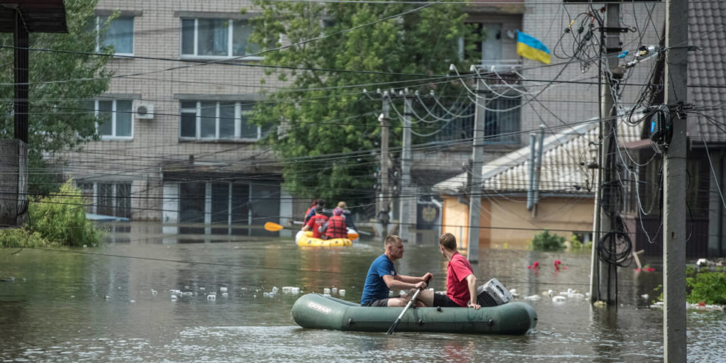 Каховская ГЭС разрушена. Местные жители плывут на лодках по затопленной улице во время эвакуации в Херсоне