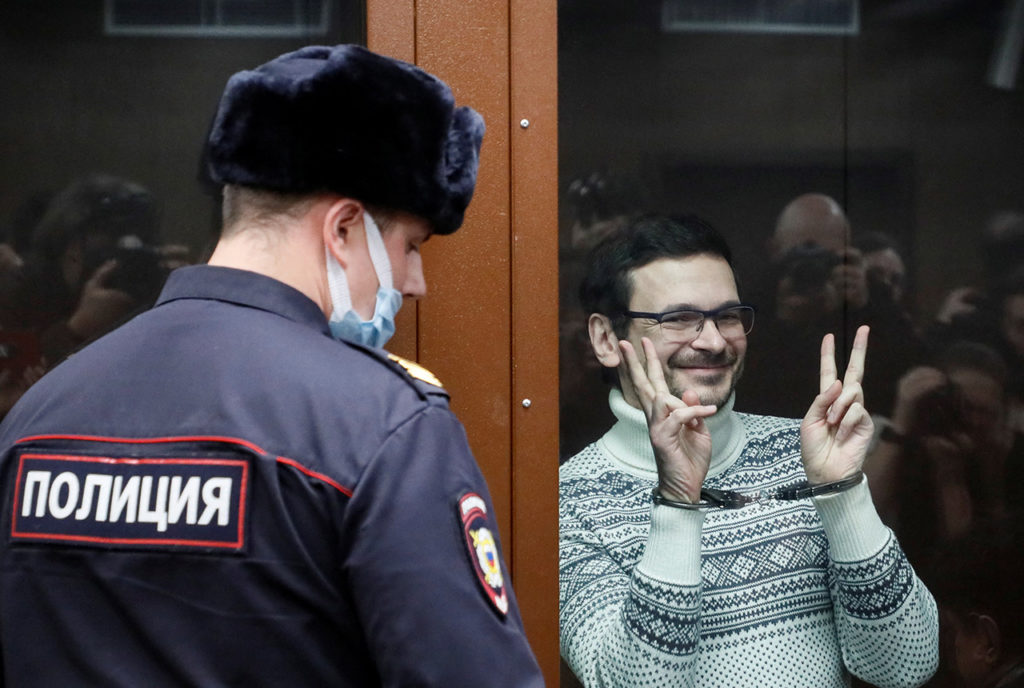 Илья Яшин жестикулирует в стеклянной клетке для подсудимых перед началом оглашения приговора в Мещанском районном суде Москвы, 9 декабря 2022 г. 