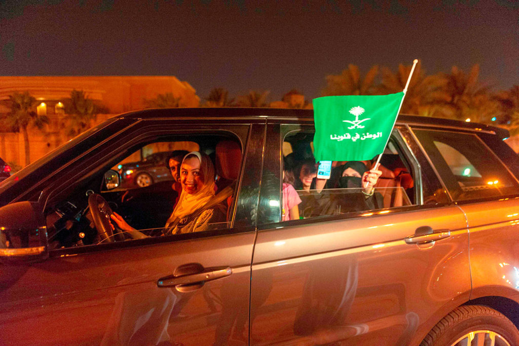 Женщина из Саудовской Аравии и ее друзья празднуют свой дебют за рулем на главной улице города Хобар по пути в Королевство Бахрейн