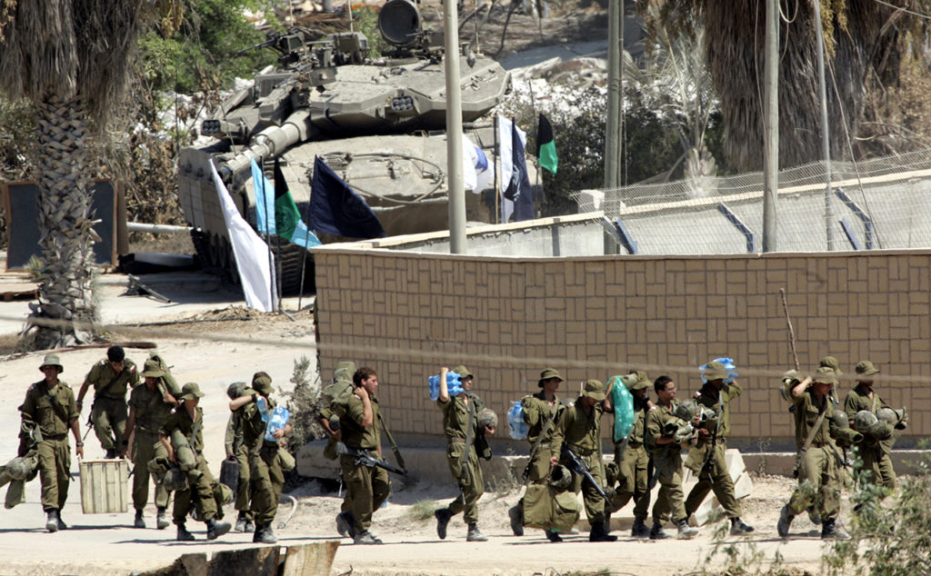 Израильские солдаты несут снаряжение, готовясь покинуть израильское поселение Кфар Даром в центральной части сектора Газа. 11 сентября 2005 года. Как закончить войну Израиля и ХАМАС