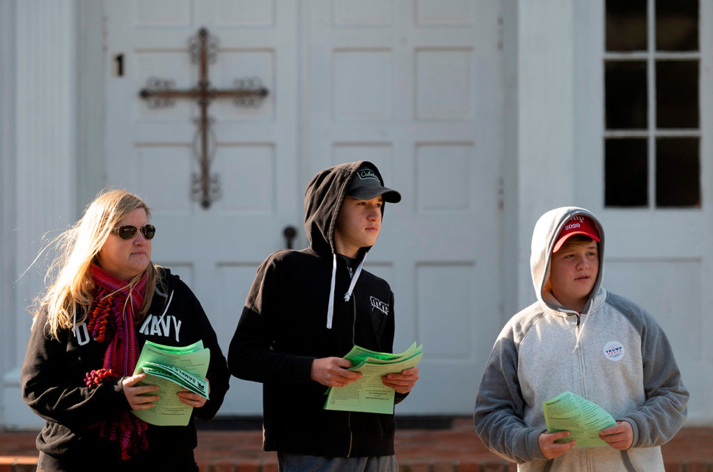 Волонтеры Республиканской партии ждут избирателей, чтобы раздать им образцы бюллетеней на избирательном участке при лютеранской церкви в штате Вирджиния, 3 ноября 2020 года.