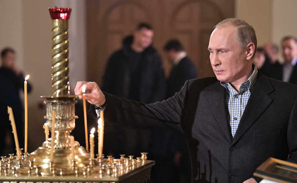 Путин ставит свечку 