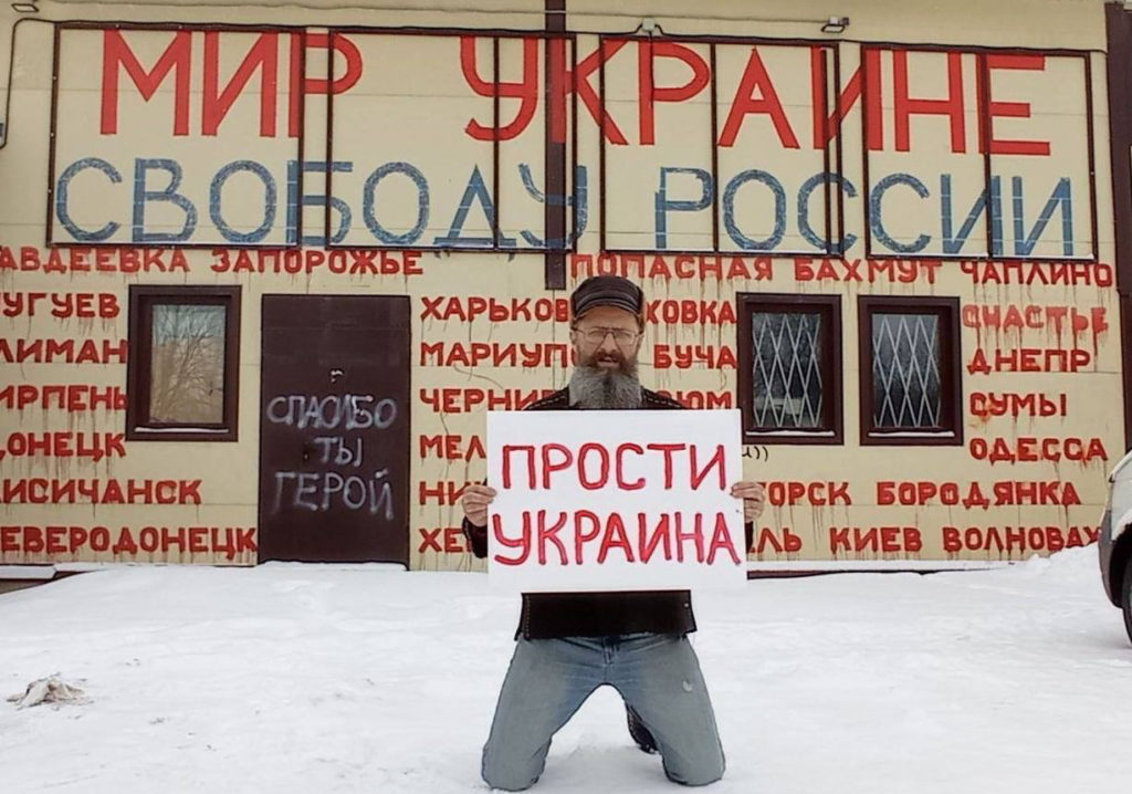 Предприниматель из Ленобласти расписал фасад своего магазина названиями украинских городов и вышел с плакатом «Прости Украина».