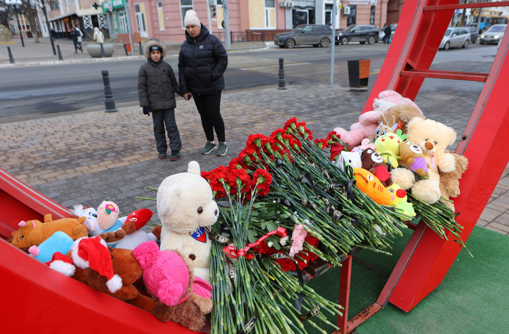 Люди возлагают цветы к импровизированному мемориалу в память о жертвах обстрела в Белгороде, 31 декабря 2023 года