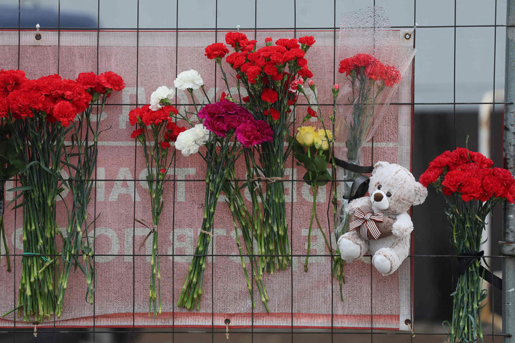 Цветы, возложенные у стихийного мемориала в память о погибших 
