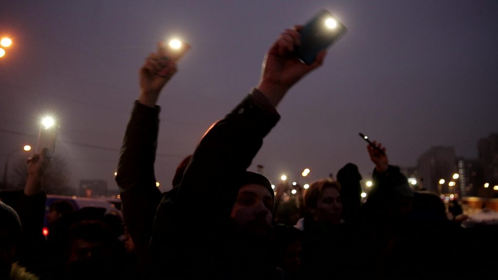 Люди светят фонариками телефонов