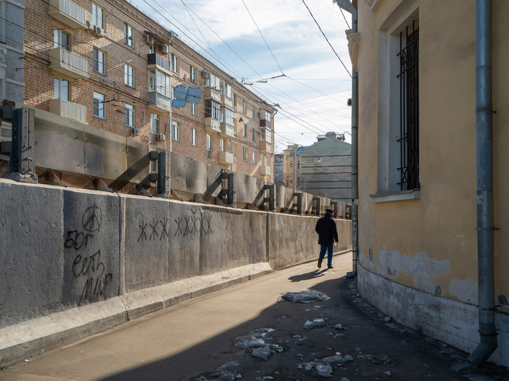 Фотография Москвы: бетонный забор, на котором написано «Бог есть мир»