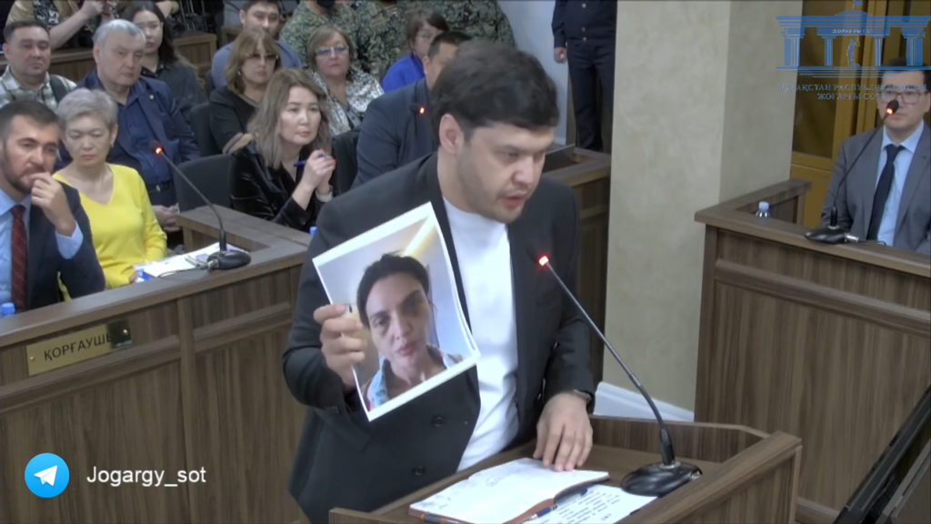 Брат Салтанат Нукеновой Айтбек Амангельды в суде показывает фото избитой сестры, которое она отправила ему.
