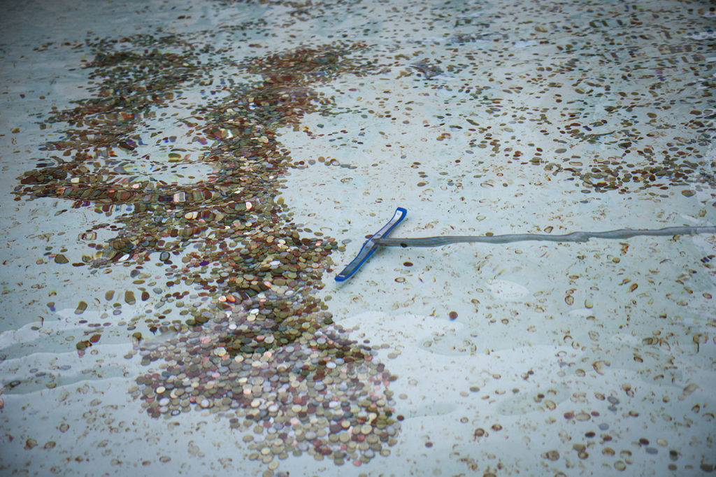 Специальная метла, которой сотрудник коммунальной компании ACEA собирает монеты в фонтане Треви