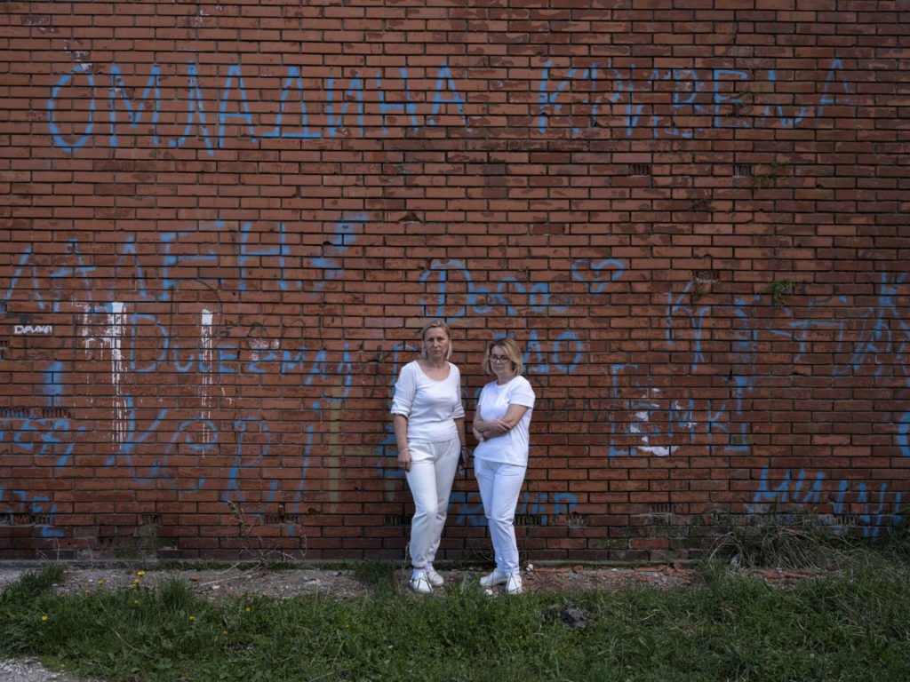 45-летняя Невенка Янкучич (слева) и ее коллега, 53-летняя Душица Бецаревич. Обе работают в деревенской школе Кривели, на фоне которой и сделано фото. 3 апреля 2024 года.